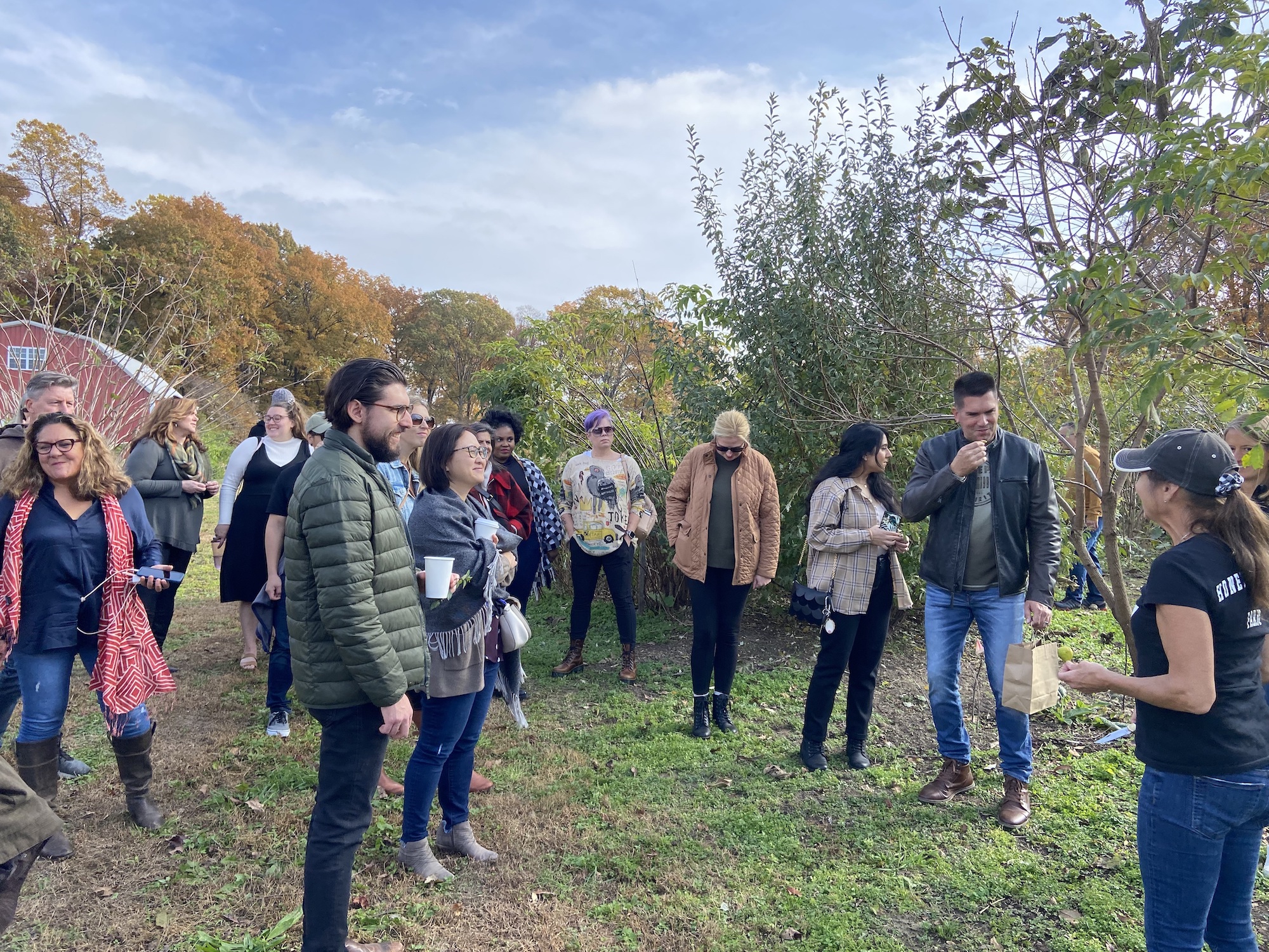 The LMD team is listening attentively, standing in a clearing surrounded by fall foliage.